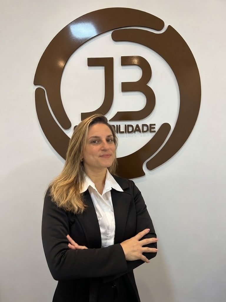 Contadora da JB Contabilidade em frente ao logotipo do escritório